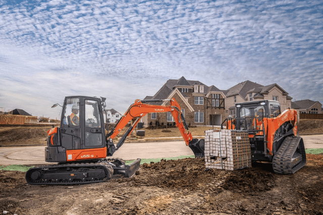 An excavator and skid steer working together on a construction site