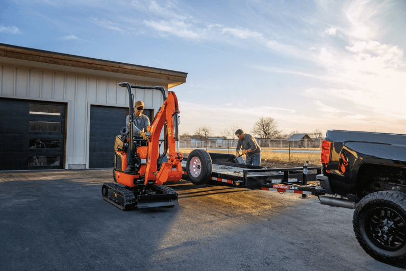 Mini excavator loading onto trailer 