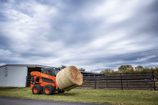 Skid Steer moving hay bale