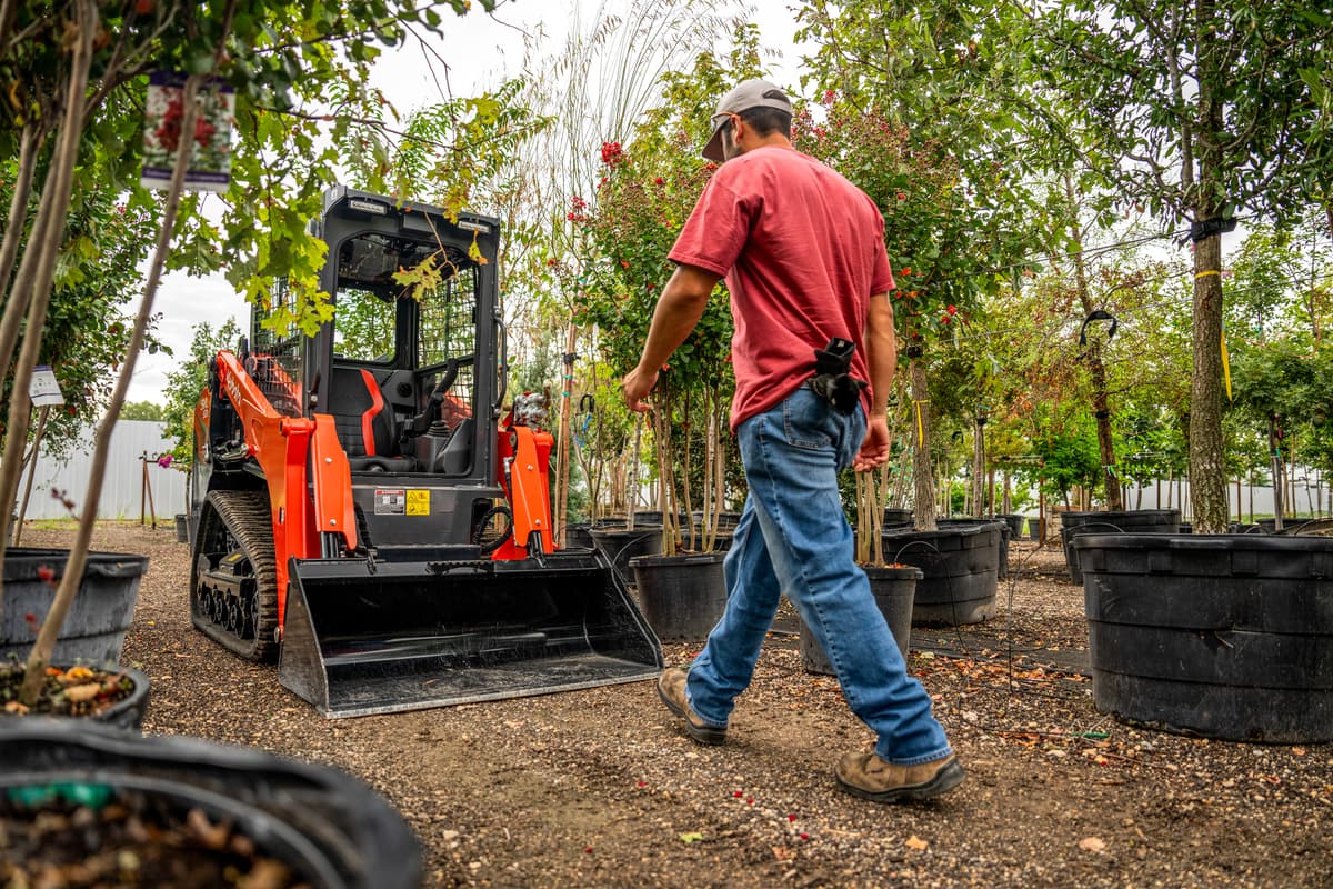 Professional horticulturist with a Kubota track loader