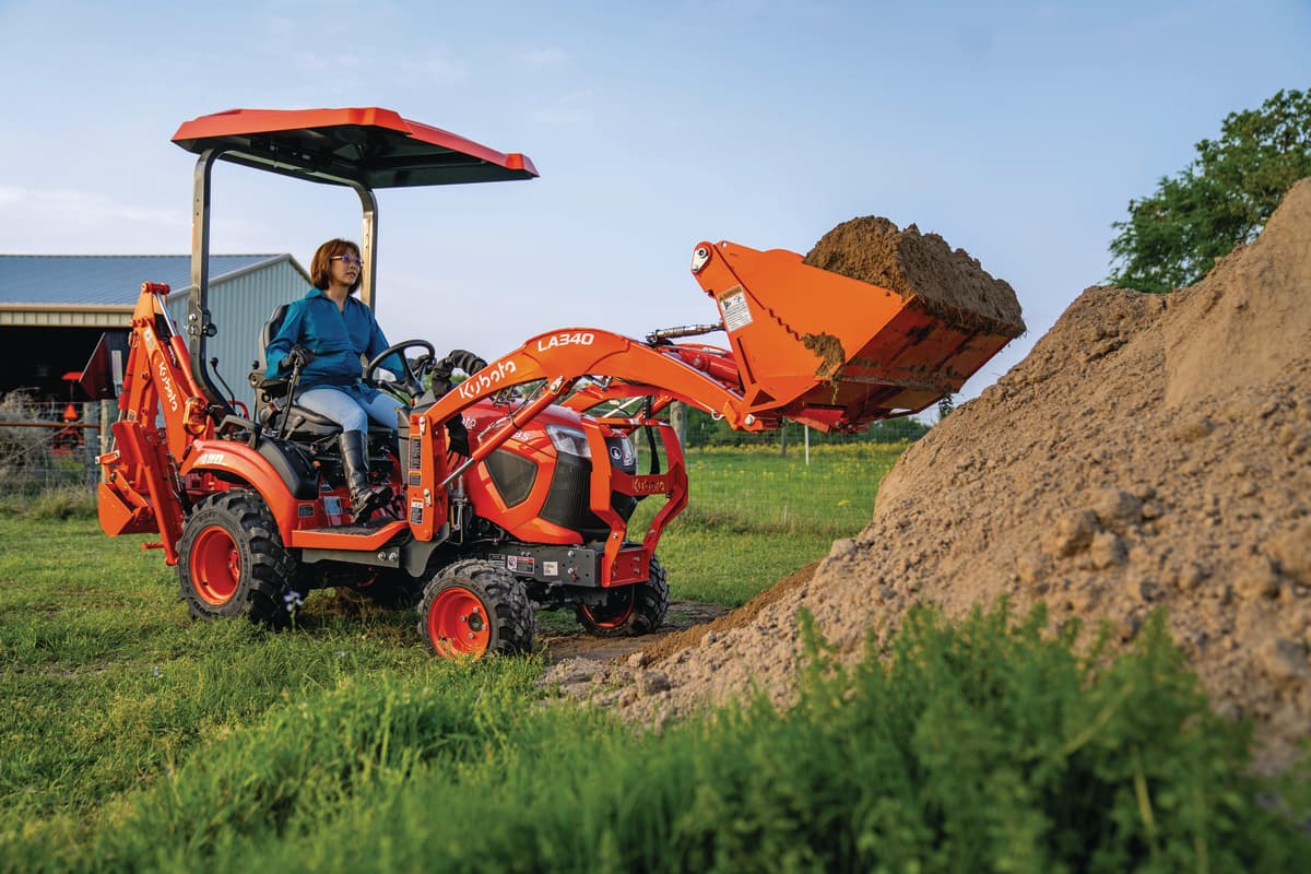 Kubota BX23S scooping dirt with the front loader