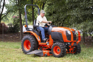 Man mowing lawn on mower from Mission Valley Kubota