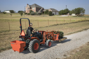 Person riding B01 tractor from Mission Valley Kubota on dirt path outside home