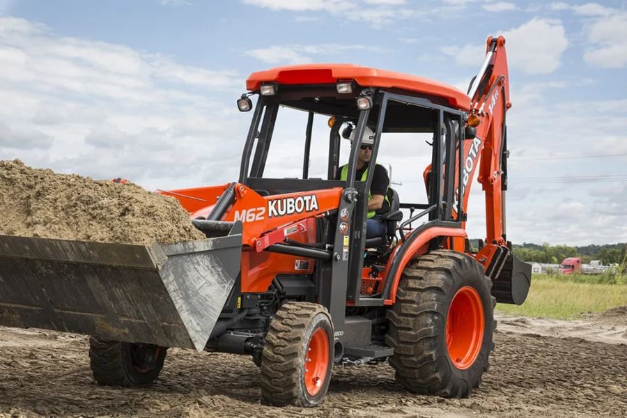 Man driving tractor, loader, backhoe from Mission Valley Kubota