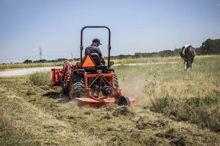 man riding tractor mower from Mission Valley Kubota in field