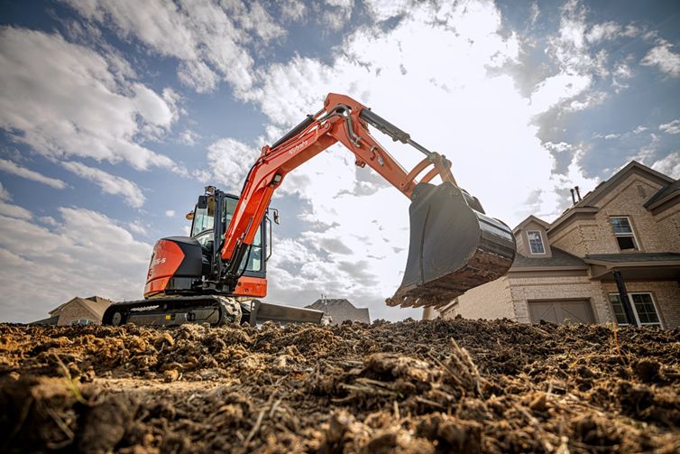 Kubota excavator from Mission Valley Kubota in dirt by wood frame house